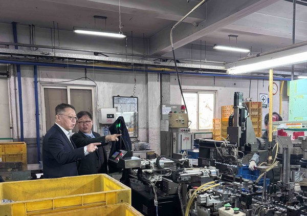 우리은행 정진완 은행장(왼쪽)이 국내 중소기업을 방문해 생산 현장에 대해 관계자로부터 설명을 듣고 있다.